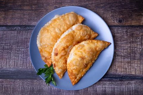 Chebureks with meat. Deep-fried flat pie. A traditional dish. Close-up. Stock Photos