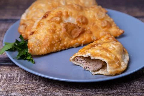 Chebureks with meat. Deep-fried flat pie. A traditional dish. Close-up. Stock Photos