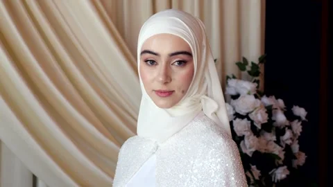 Chechen bride in hijab looks at camera in elegant wedding interior. slow motion Vidéo 313902306