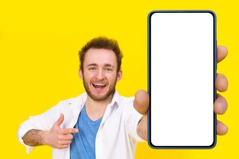 Check this app young man pointing at smartphone showing a white empty screen Stock Photos