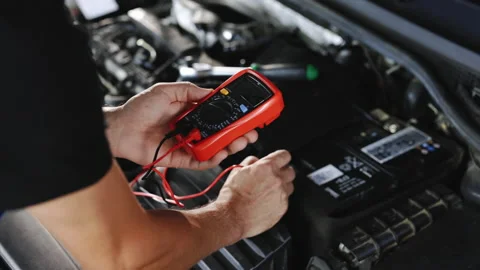 Check battery voltage with electric multimeter. Car starter battery Stock Footage 203554605