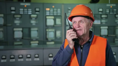 Check control. Male engineer in a orange helmet looks at control panel buttons Stock Footage 146131423
