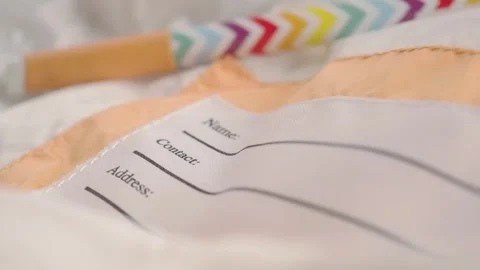 Check list and name tag on fabric surface Stock Footage 335975544