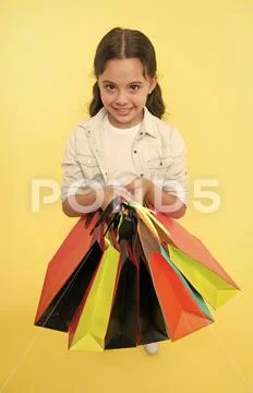 Check out her shopping packages. Child cute shopaholic with bunch shopping bags Stock Photos