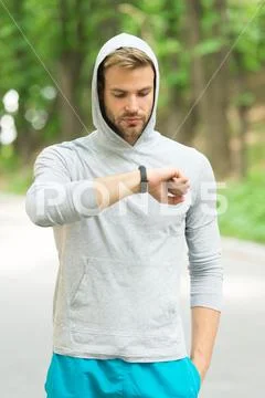 Check time his best score. Man athlete busy face check fitness tracker nature Stock Photos
