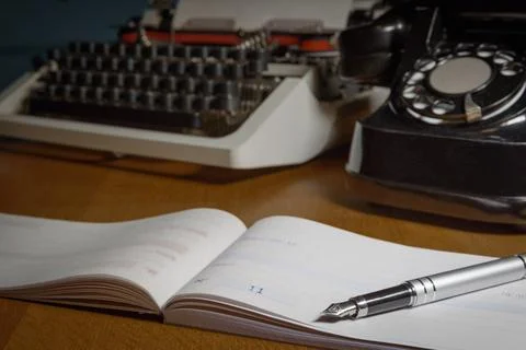 Checkbook, ink pen, retro typewriter and old telephone on the table. . Sele.. Stock Photos