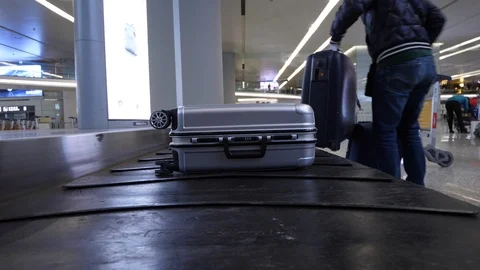Checked baggage move on conveyor at luggage claim hall of airport Video stock 92964432