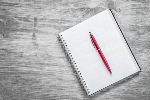 Checked notepad pen on wooden board office concept Stock Photos