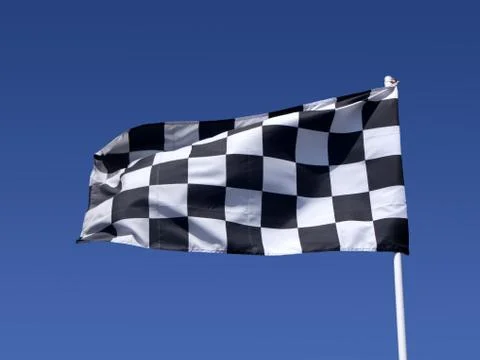 A checkered flag blowing in the wind at the end of a motor race. Photos