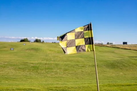 A checkered flag on a golf course signifying a hole Stock Photos