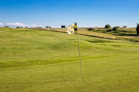 A checkered flag on a golf course signifying a hole Stock Photos