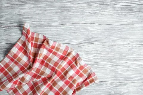 Checkered napkin at left bottom corner of gray wooden background Stock Photos