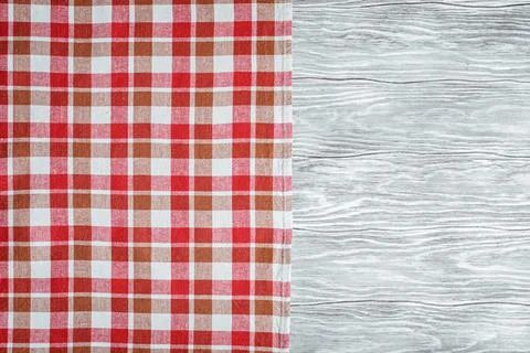 Checkered napkin at left side of gray wooden background Fotos de archivo