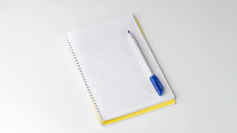 Checkered notebook with pen on white background, space for inscription Stock Photos