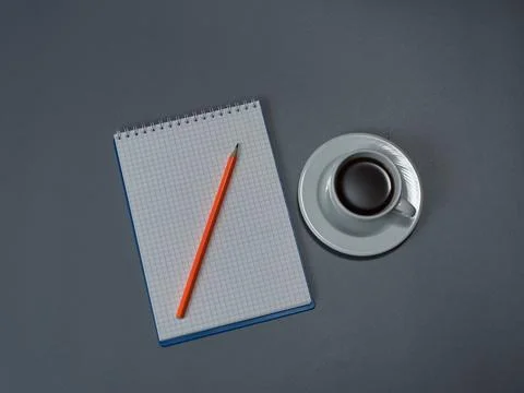 A checkered notebook with a pencil and a cup of coffee Stock Photos