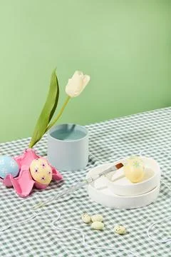 Checkered tablecloth featured a stack of ceramic dishes with a yellow egg pla Stock Photos