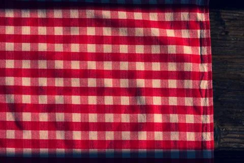 The checkered tablecloth on a table. Texture of white fabric in a red cell. Stock Photos