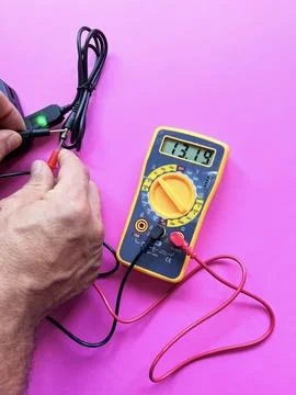 Checking the adapter voltage with a multimeter. on the background Stock Photos