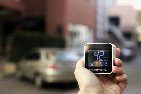 Checking air quality with hand held PM2.5 sensor device. PM2.5 particles dust Stock Photos