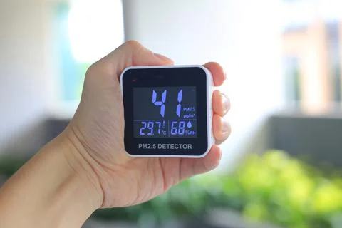 Checking air quality with hand held PM2.5 sensor device. PM2.5 particles dust Stock Photos