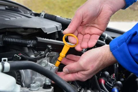 Checking the amount of oil in the car engine via the level control rod Stock Photos