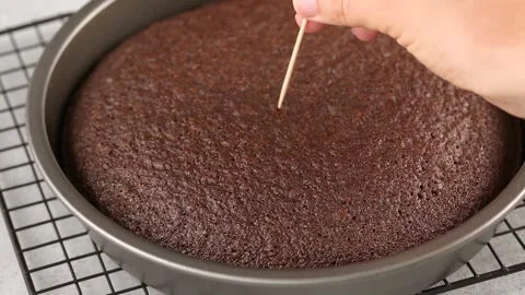 Checking baked chocolate cake with a toothpick Stock Footage 242525784