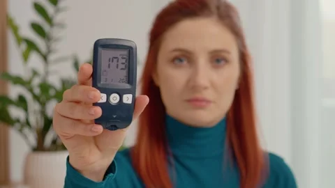 Checking blood sugar level after a meal shows high reading of 173 mg dL Stock Footage 334034523