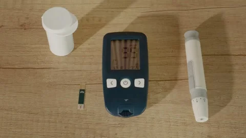 Checking blood sugar levels with glucometer on wooden table Stock Footage 334033128