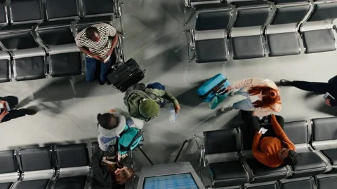 Checking boarding timetable, travel documents and top down view of passengers Video stock 334781718