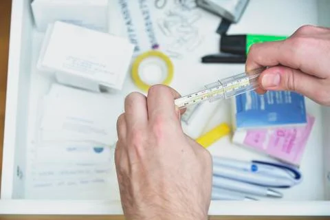 Checking body temperature with a thermometer Stock Photos
