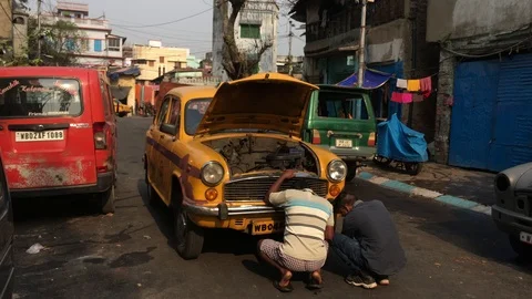 Checking break down yellow colored taxi in the middle of the road Stock Footage 104839064