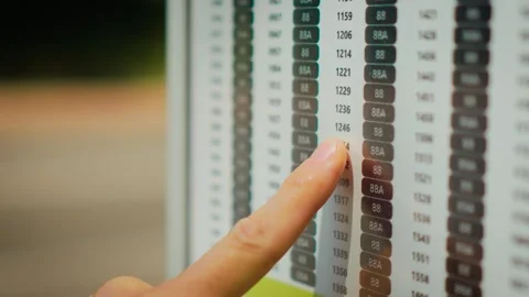 Checking bus timetable at public transport stop on empty urban street during Видео 338069524