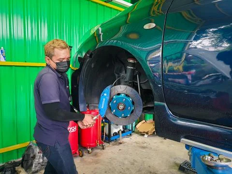 Checking car brake system for repair at car garage Stock Photos