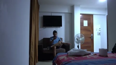Checking the cell phone sitting on the sofa of a hotel Stock Footage 196733045