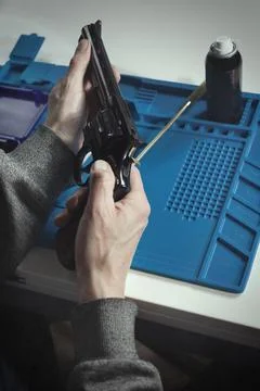 Checking, cleaning and loading of black finished .357 magnum revolver handgun Stock Photos