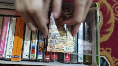Checking the collection of music cassettes neatly arranged in a box Stock Footage 277051013