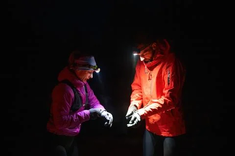 Checking Coordinates During Night Hike.Couple night hikers examine a device Stock Photos