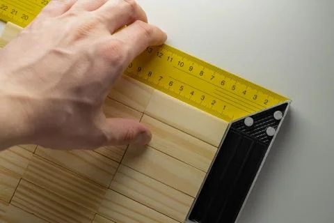 Checking the corner of the table, hand with corner ruler and wooden blocks table Foto stock