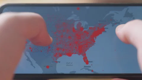 Checking coronavirus epidemic status in mobile phone at home Stock Footage 128241568