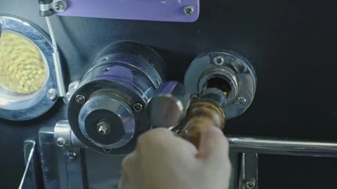 Checking the degree of roasting of coffee beans in the roaster machine. Close Vídeos de archivo 142087805