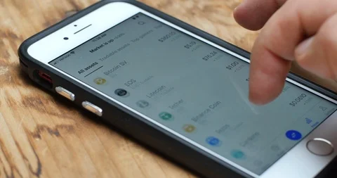 Checking Different Cryptocurrencies on Phone Stock Footage 126359486