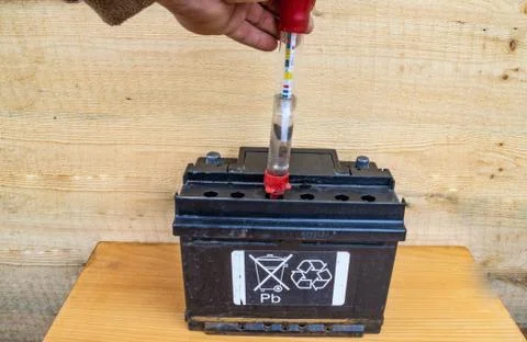 Checking the electrolyte density of the battery with a hydrometer Stock Photos