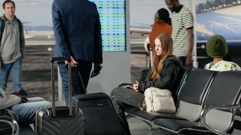 Checking electronic departure board, timetable and men with women in airport Stock Footage 333652451