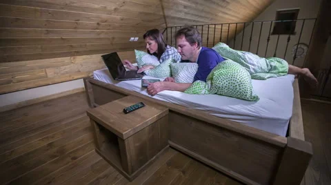 Checking electronic device in bed and then watching TV Video stock 61364258