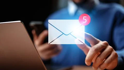 Checking email notifications on a computer and smartphone while working from 스톡 사진