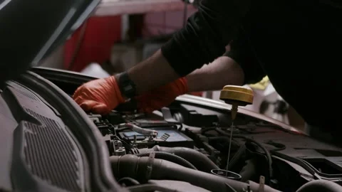 Checking engine oil dipstick inside car engine bay 库存影片 332042688