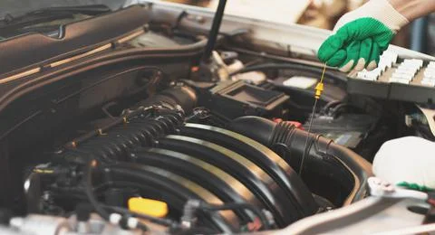 Checking the engine oil level by a mechanic in a car service Stock Photos