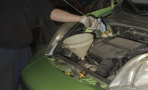 Checking the engine oil level. Topping up to the required level 스톡 사진