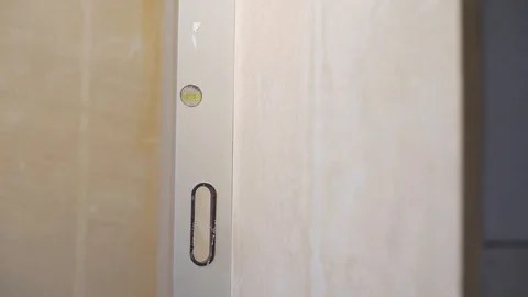 Checking evenness of vertical wall with bubble level Stock Footage 102907084