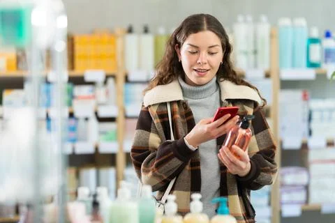 Checking expiration date of liquid hand soap - female shopper in winter clothes Stock Photos